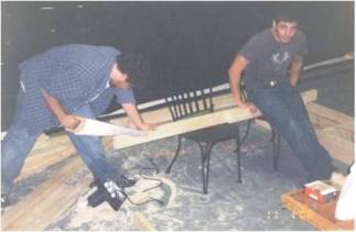 Left to right: Pledges Miles Vining and James Balchunas cut wood for the first annual Shipwreck Party, 2006.